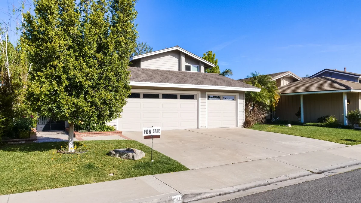 Suburban house with a three-car garage and a palm tree.