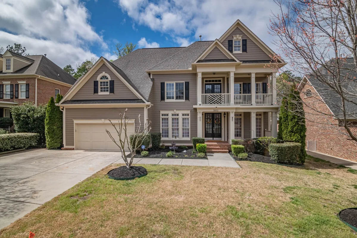 A two-story suburban house with a well-maintained lawn and facade.