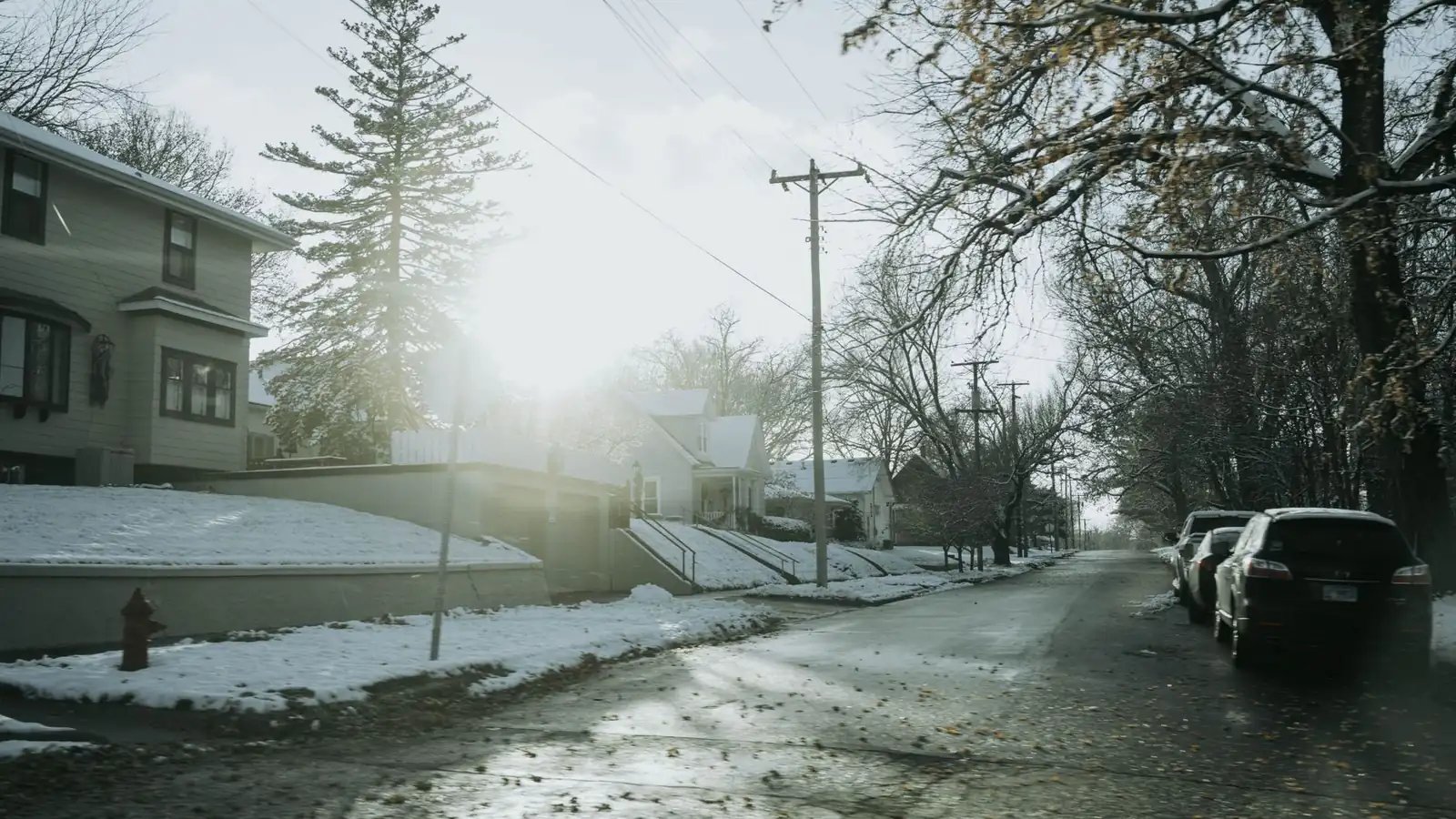 Snowy residential street of frame houses in Dixon, Illinois, in low winter sun