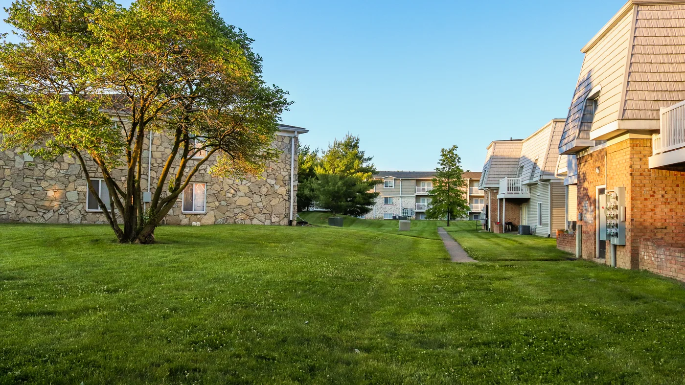 Brick and stone residential buildings with a lawn and trees in Indianapolis, Indiana