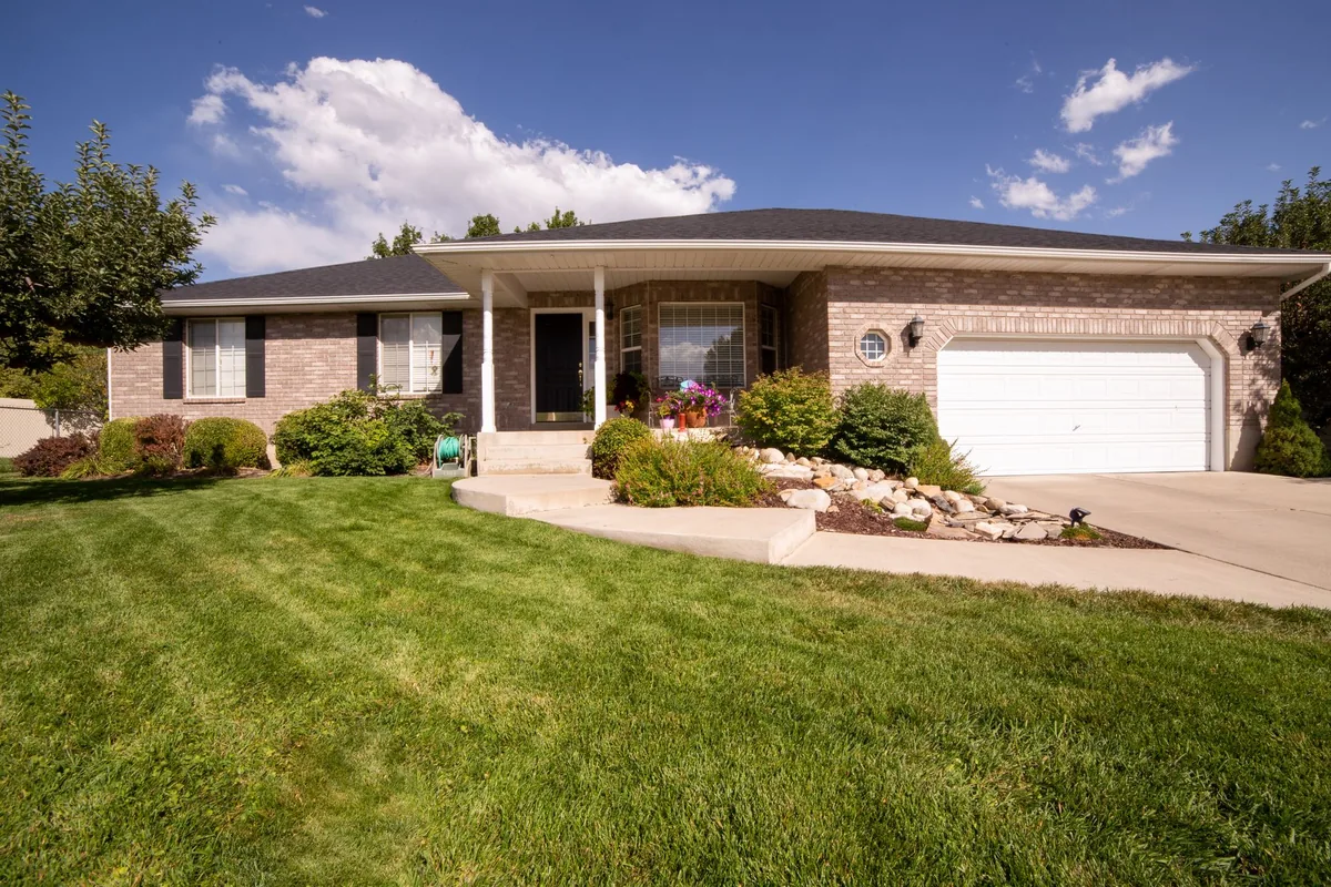 A modern suburban house exterior with a landscaped yard on a sunny day.