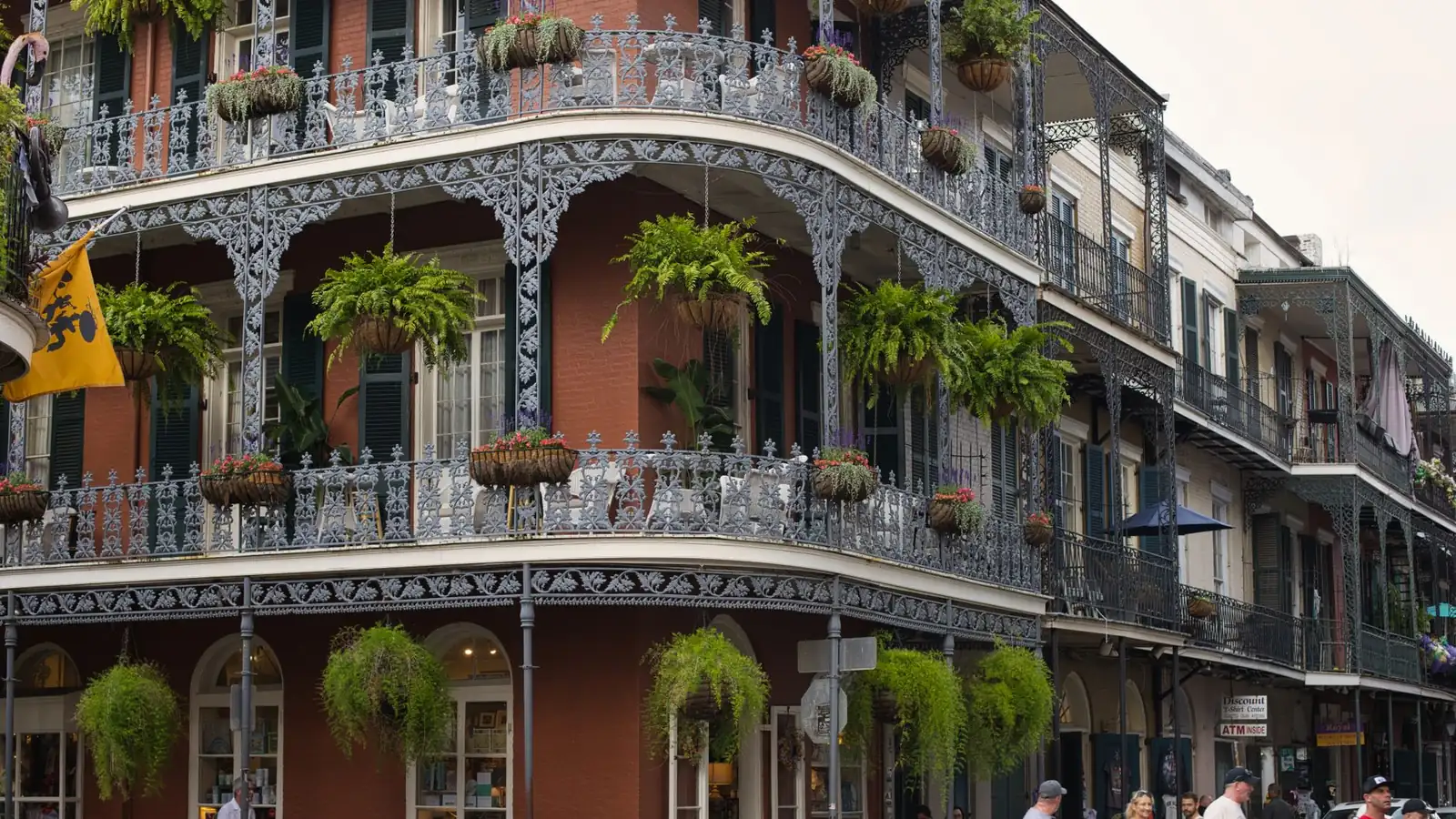Wrought-iron galleries hung with ferns and flowers on a corner building in the French Quarter, New Orleans