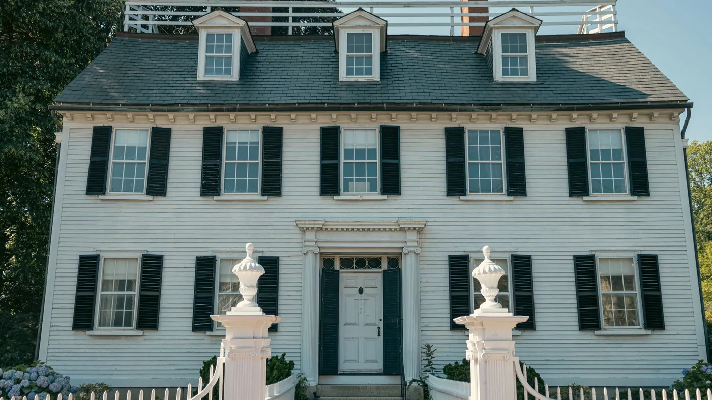 Well-kept white colonial home with black shutters and a picket fence in Salem, Massachusetts