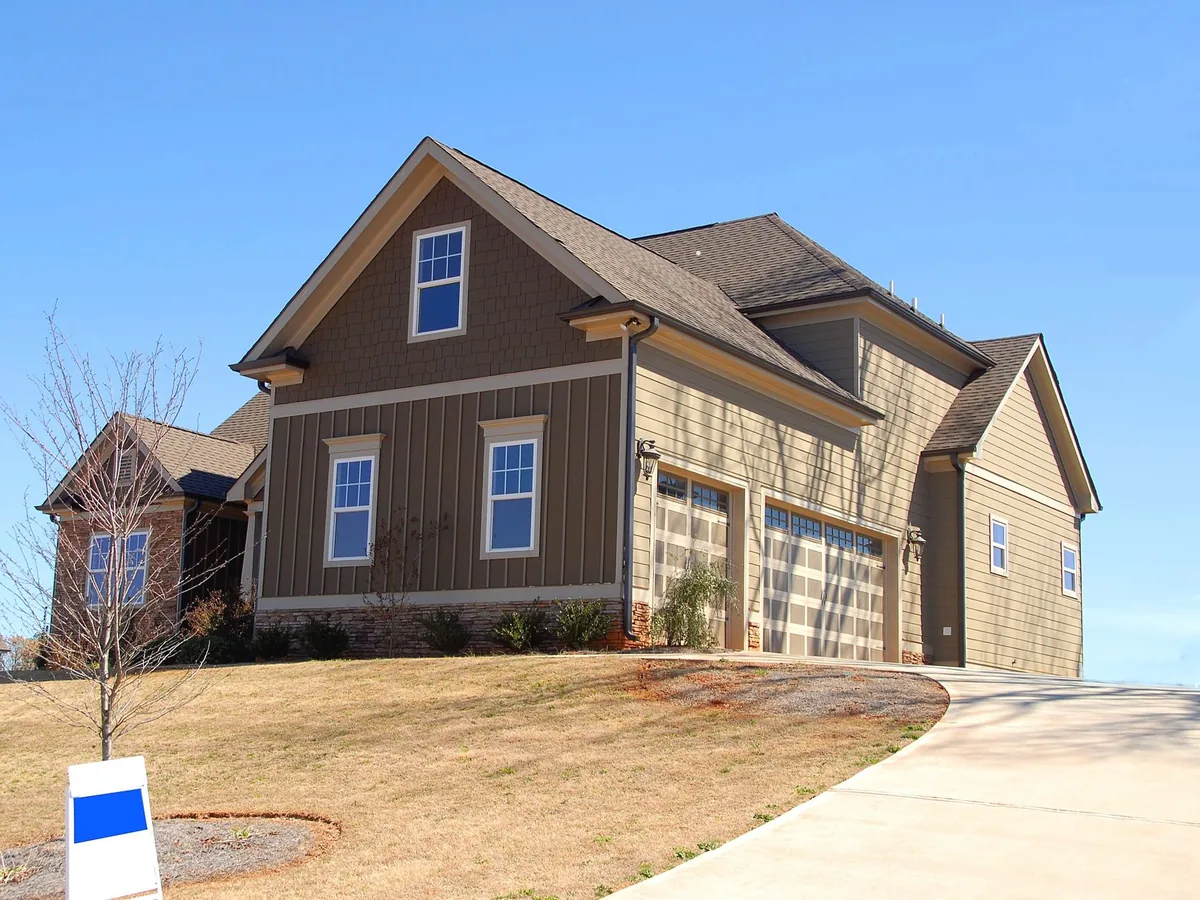 Family home for sale in suburb with spacious garage and landscaped lawn.