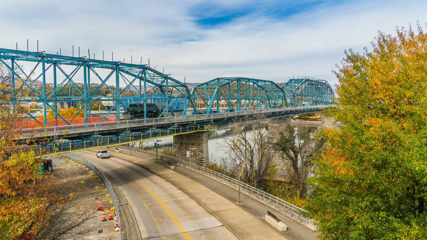 The blue steel Walnut Street Bridge over the Tennessee River at Chattanooga, framed by autumn foliage