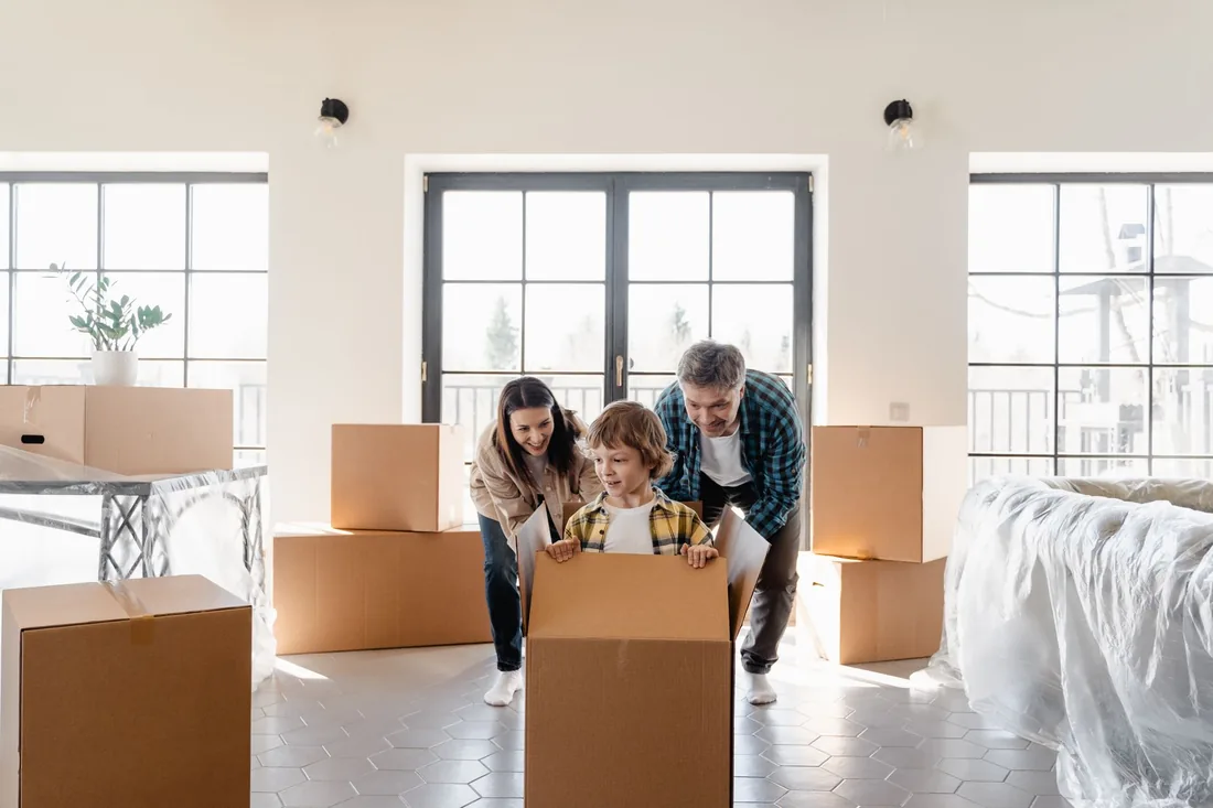 Family with moving boxes in a bright room of a new home