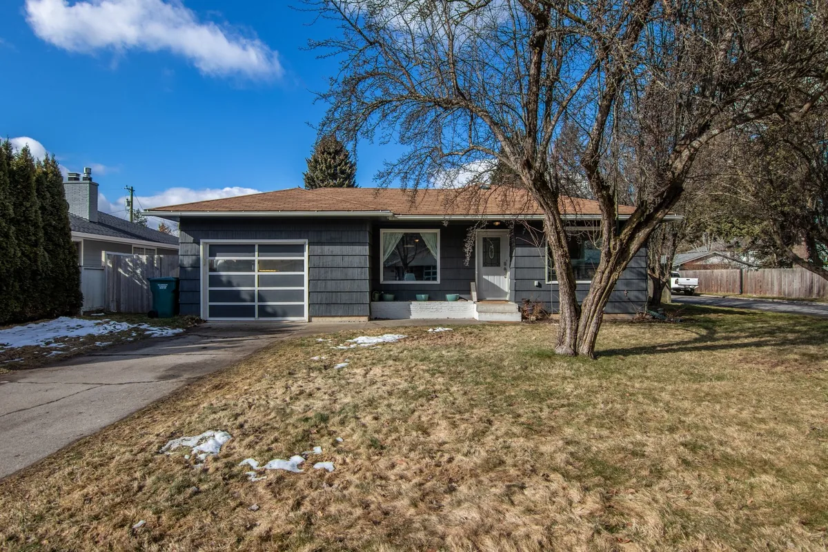 Single-story house with a front yard and bare trees on a sunny winter day.